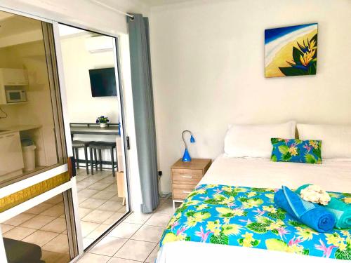 1 dormitorio con 1 cama y balcón con mesa en Avarua Escape, Rarotonga, en Avarua