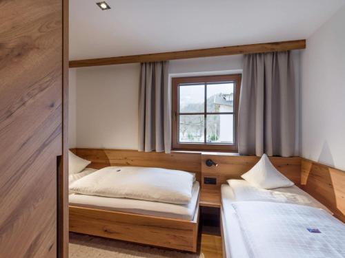 two beds in a room with a window at Ferienhof Oblasser in Mayrhofen