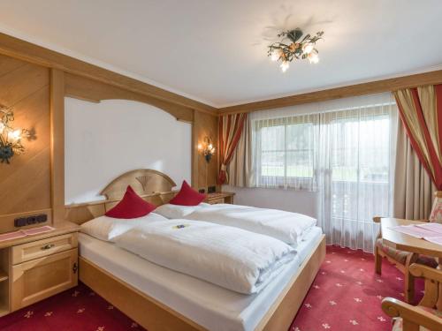 a hotel room with a large bed and a table at Ferienhof Oblasser in Mayrhofen