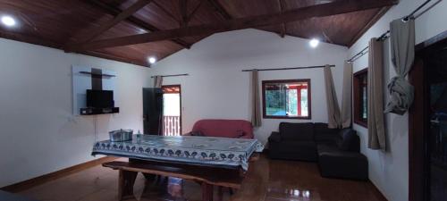 a living room with a table and a couch at Casa do Vani - Lapinha da Serra in Santana do Riacho