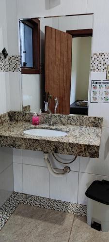 a bathroom counter with a sink and a toilet at Casa do Vani - Lapinha da Serra in Santana do Riacho