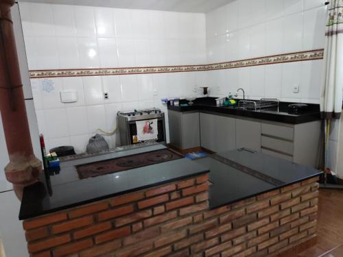a kitchen with a brick counter top and a stove at Casa do Vani - Lapinha da Serra in Santana do Riacho