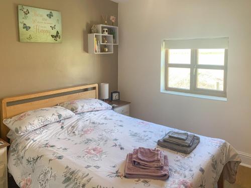 a bedroom with a bed with towels on it at Cloverleaf in Saltfleetby Saint Clement