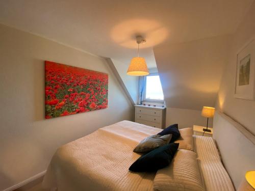 1 dormitorio con 1 cama con una pintura en la pared en Residenz Darssblick en Barth
