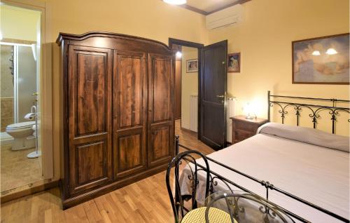a bedroom with a bed and a large wooden cabinet at Amazing Home In Rivotorto Di Assisi in Passaggio Di Assisi