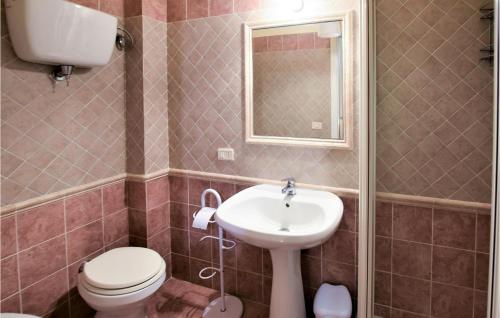a bathroom with a sink and a toilet and a mirror at Amazing Home In Rivotorto Di Assisi in Passaggio Di Assisi
