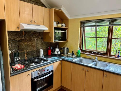 a kitchen with a stove and a sink at Woodvale at Cooma in Cooma