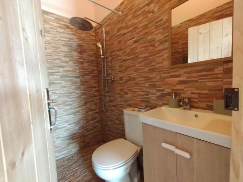 a bathroom with a toilet and a sink and a mirror at Refúgio na Aldeia in Ourique