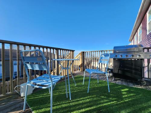 zwei blaue Stühle auf einer Terrasse mit Grill in der Unterkunft Big 3 bedrooms 2 stories townhouse Near Downtown in Halifax