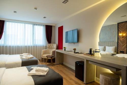 a hotel room with two beds and a desk at Linda Port Hotel in Istanbul
