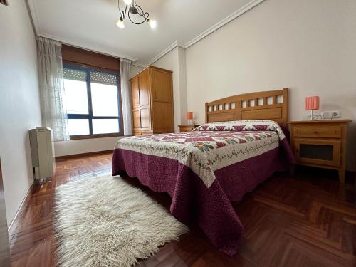 sypialnia z łóżkiem, oknem i dywanem w obiekcie Apartamento Salgueirón w mieście Cangas de Morrazo