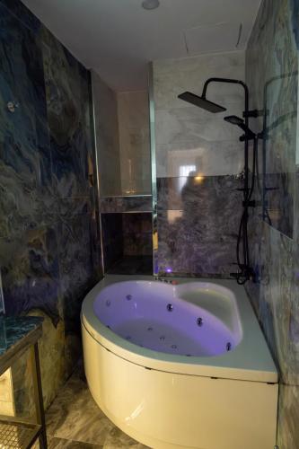 a bathroom with a purple tub in a room at Linda Port Hotel in Istanbul
