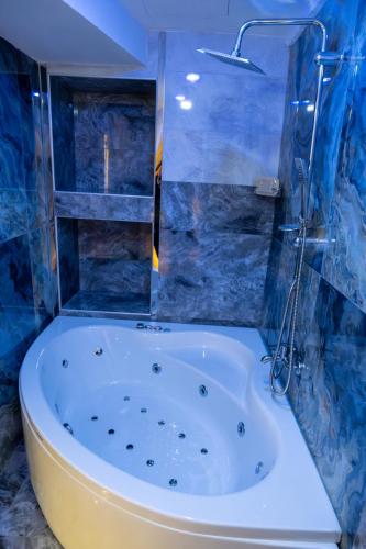 a bath tub in a bathroom with blue tiles at Linda Port Hotel in Istanbul