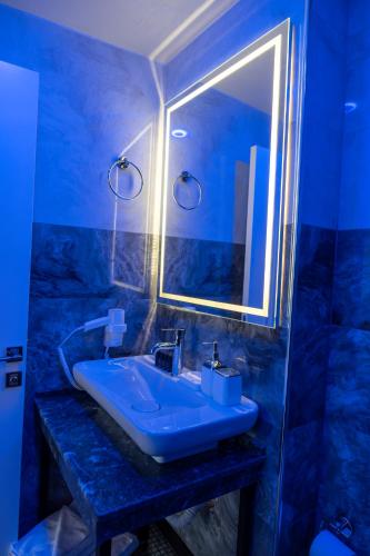 a blue bathroom with a sink and a mirror at Linda Port Hotel in Istanbul