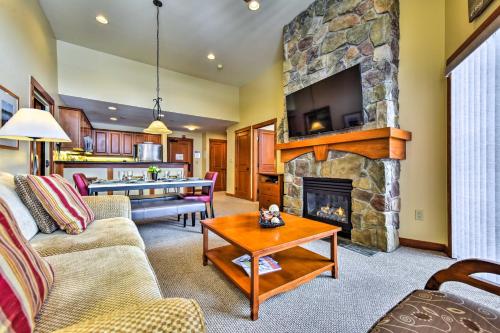 a living room with a stone fireplace with a tv at Ski-InandSki-Out Solitude Resort Condo with Mtn Views! in Solitude