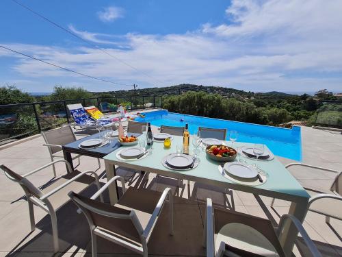 - une table et des chaises sur une terrasse avec piscine dans l'établissement Villa Mekasteni, à Cirendinu