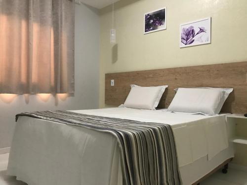 1 dormitorio con 1 cama grande con sábanas blancas en Hotel pousada a Cabana en Maceió