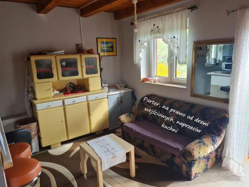 ein Wohnzimmer mit einem Sofa und einem Tisch in der Unterkunft Domek letniskowy w Szkotowie in Szkotowo