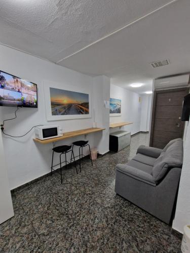 a living room with a couch and a tv on a wall at Old Center Inn Alicante in Alicante