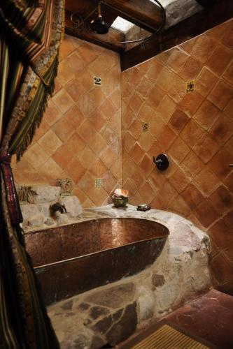 a bathroom with a large wooden tub in a room at Hacienda Rumiloma in Quito