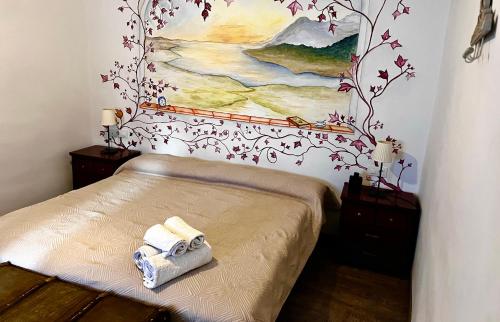 1 dormitorio con 1 cama con una pintura en la pared en Destino Deluxe Plaza De Santiago - 2 hab en Cáceres