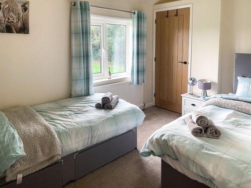 a bedroom with two beds and a window at Old Alton Hall Farmhouse in Tattingstone