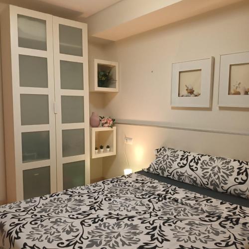 a bedroom with a bed with a black and white bedspread at Bcn apartments in Hospitalet de Llobregat