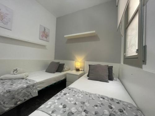 een slaapkamer met 2 bedden en een raam bij Mistral Barcelona Centro in Barcelona