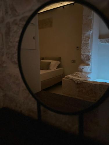 a mirror in front of a room with a couch at BORGANTHIA - IL CHIOSTRO DEI MEDICI in Alberobello
