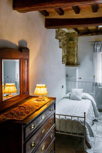 a bedroom with a dresser and a bed with a mirror at La Casetta Nel Borgo in Castelnuovo di Val di Cecina
