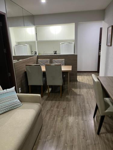 a dining room with a table and chairs and a couch at Hotel Via Premiere - Rio Centro in Rio de Janeiro