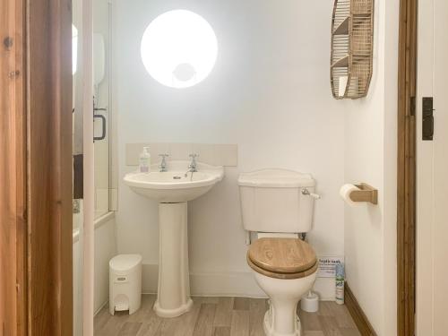 een badkamer met een toilet en een wastafel bij Wheatsheaf Cottage - 80021 in Sawdon