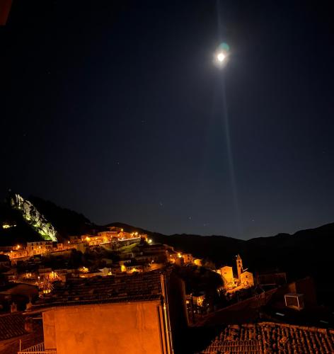 a view of a city at night with the moon at A due passi in Pietrapertosa