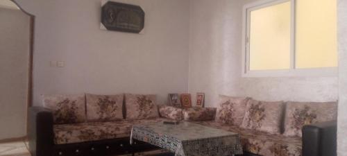 uma sala de estar com um sofá e uma mesa em شقة العتماني للكراء اليومي em Rissani