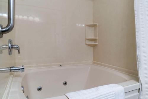 a white bath tub in a bathroom with a towel at Comfort Inn East Oregon - Toledo in Oregon