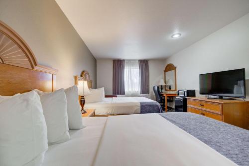 um quarto de hotel com duas camas e uma televisão de ecrã plano em Econo Lodge Livingston Gateway to Yellowstone em Livingston