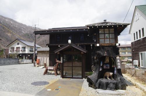 a small tree house with a bear laying on a tree stump at Tsuyukusa in Takayama
