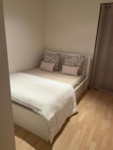 a small bedroom with a bed with two pillows at Saint-Cosme Home in Chalon-sur-Saône