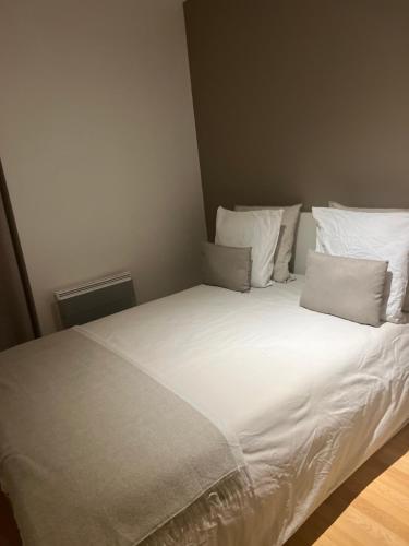 a bed with white sheets and pillows in a room at Saint-Cosme Home in Chalon-sur-Saône