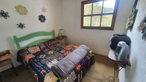 ein Schlafzimmer mit einem Bett und einem TV auf einem Tisch in der Unterkunft Casa Morango Gonçalves in Gonçalves
