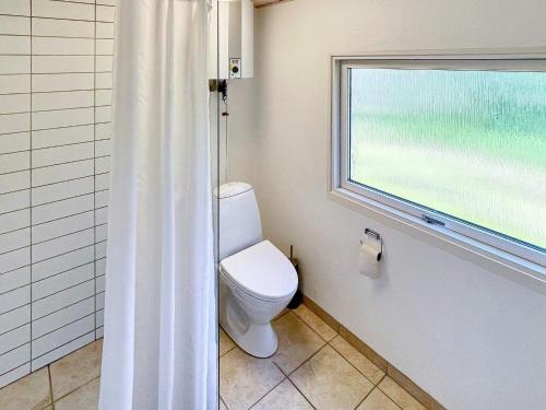een badkamer met een toilet en een raam bij Holiday home Ørsted XXIII in Ørsted