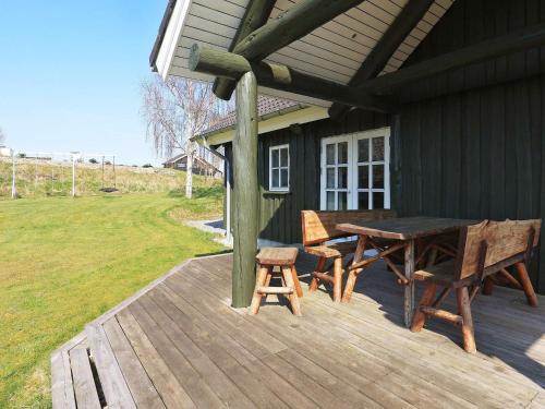 a wooden deck with a table and chairs on a house at 8 person holiday home in L gstrup in Hjarbæk