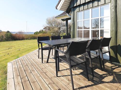 a wooden deck with a table and chairs on it at 8 person holiday home in L gstrup in Hjarbæk