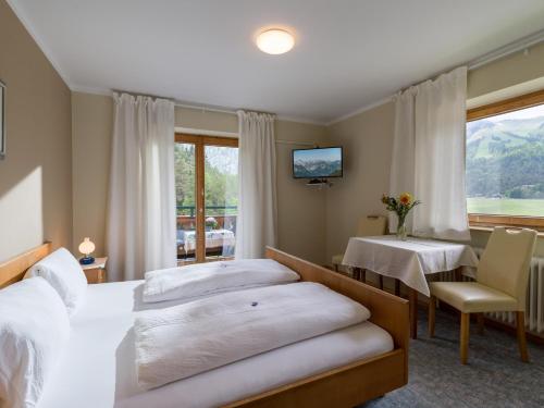 ein Hotelzimmer mit 2 Betten und einem Tisch in der Unterkunft Pension Englhof in Achenkirch