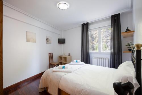 Un dormitorio con una gran cama blanca y una ventana en Magdalena - baskeyrentals en Ondárroa