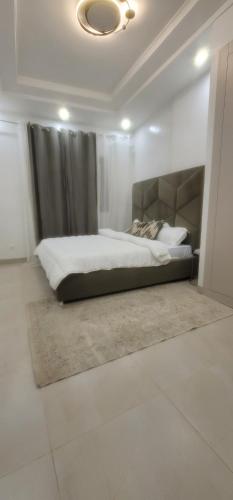 a bedroom with a large bed with a headboard at Go to the top in Dakar