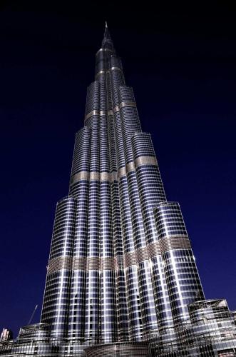 een hoog gebouw met 's nachts verlichting bij Jumera in Dubai