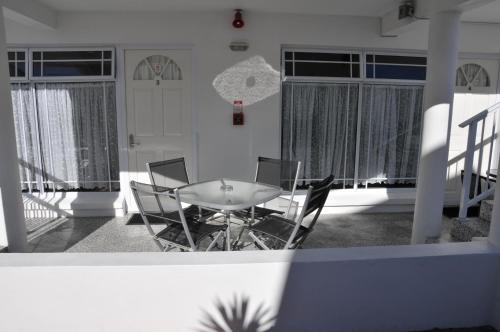 una mesa y sillas en una habitación con ventanas en Lakeside Taupo Motel, en Taupo