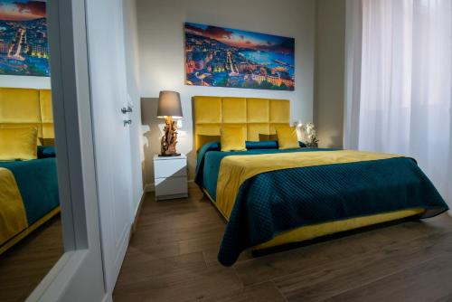 a bedroom with two beds and a painting on the wall at VIVI A NAPOLI in Naples