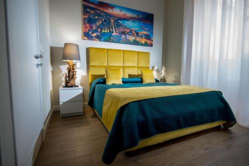 a bedroom with a large bed with a yellow headboard at VIVI A NAPOLI in Naples